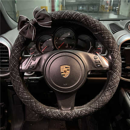 Elegant chanel-style steering wheel cover with a bow, crafted from cotton linen, adorning a porsche dashboard for a luxurious...
