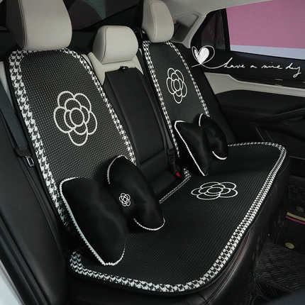 Elegant black and white houndstooth camellia ice silk car cushion set with honeycomb cooling design, featuring decorative pil...
