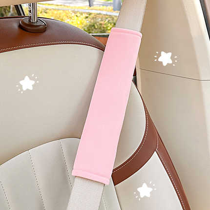 Pink universal seat belt shoulder protector with anti-strain design, snugly fitted on a car seat for comfort and style.