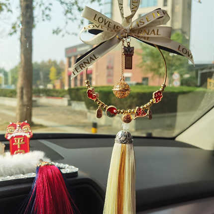 Elegant chinese mai sui na fu car pendant featuring a handwoven mirror charm with gold beads, red accents, and a tassel, perf...