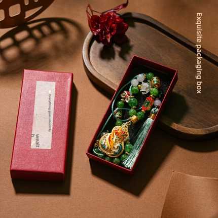 Elegant fu lu ping an car pendant featuring handmade beaded design with vibrant green and gold accents, nestled in an exquisi...
