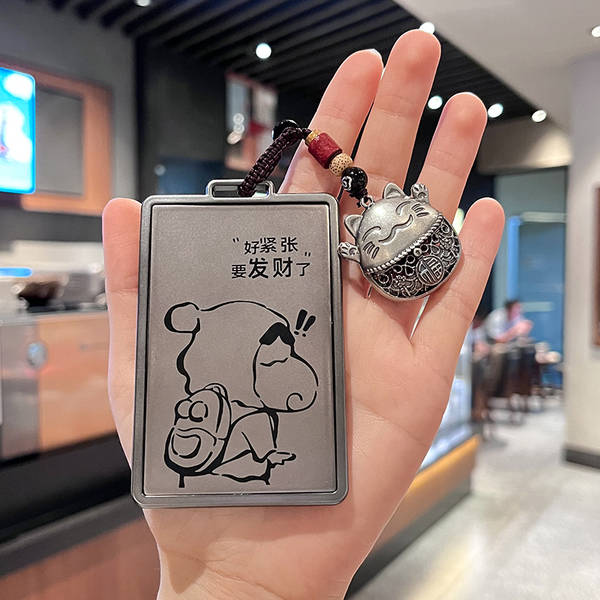 A hand holds a denza d9 nfc card key cover featuring a cartoon bear with the text good luck, lets get rich! and a lucky cat c...