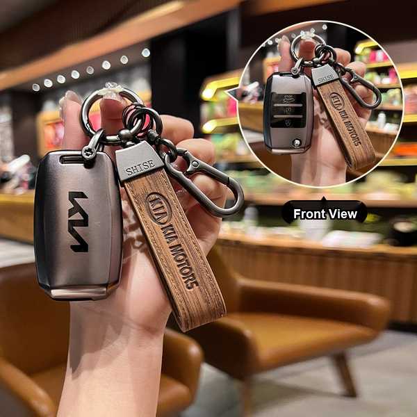 Hand holding a kia k3 key cover with wooden strap, showcasing front view of the sleek design and car key fob.