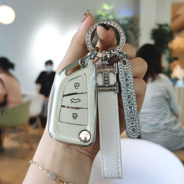 A hand holds a ds master blade key cover for iron general kd shell, featuring a sleek white design with diamond accents and a...