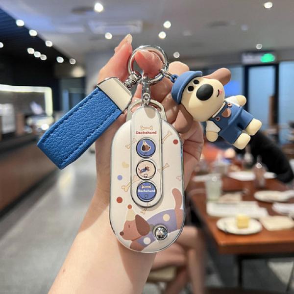 A hand holds a wuling hongguang mini ev car key cover featuring a cute macaron-style design with playful dog illustrations an...
