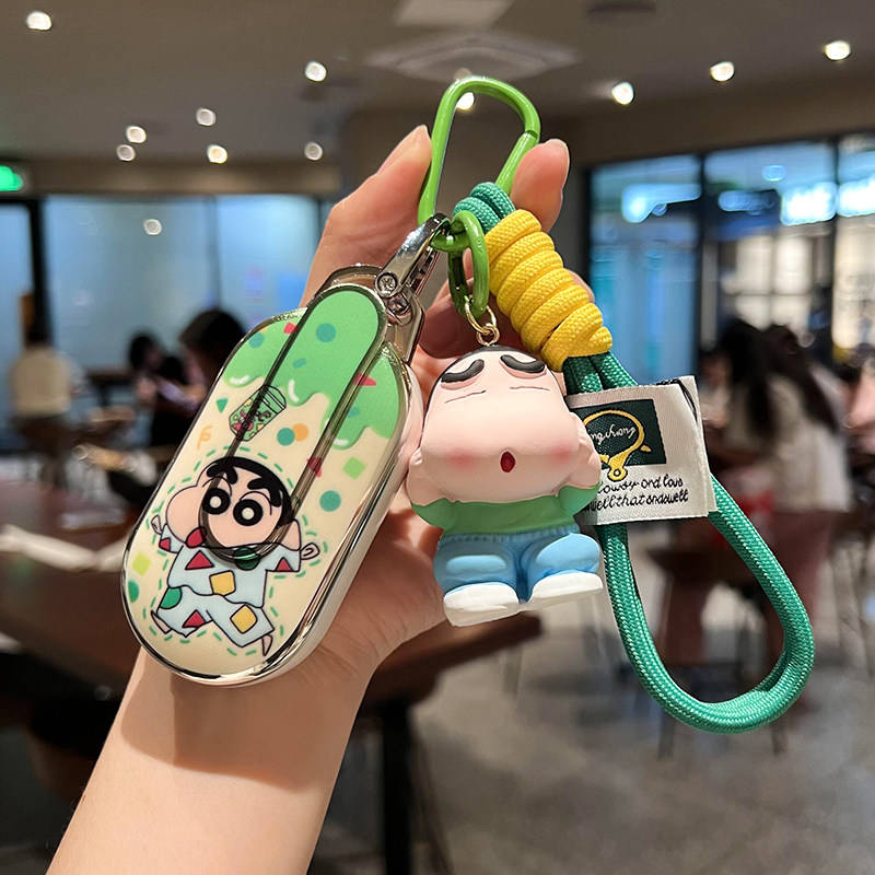 A hand holds a wuling hongguang mini ev car key cover featuring a cartoon design with a green and yellow strap, perfect for a...