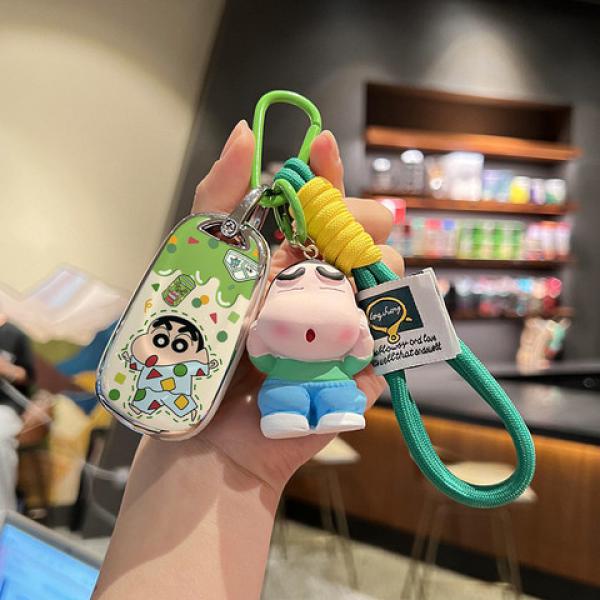 A hand holds a colorful keychain featuring a cartoon character, with a green silicone key cover designed for buick velite pro...