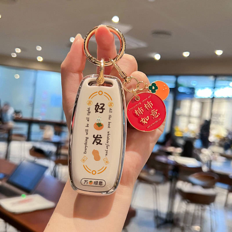 A hand holds a stylish nissan altima key cover with and text, featuring a red charm with for good luck, set in a ...