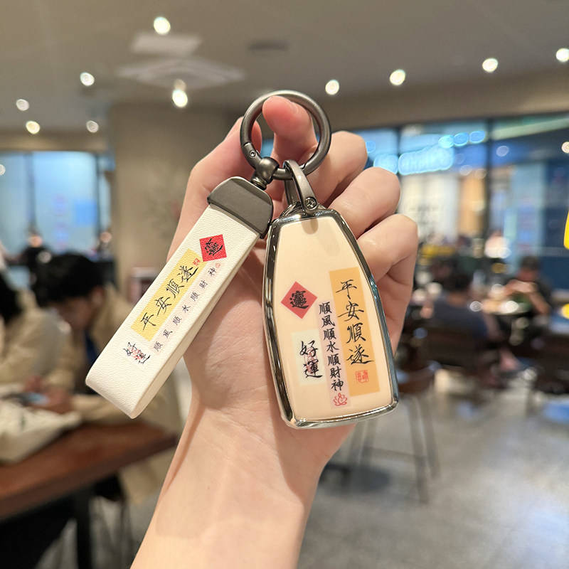 A hand holds a stylish key cover for the hongqi hs5, featuring and inscriptions, perfect for 2023 models including h5...