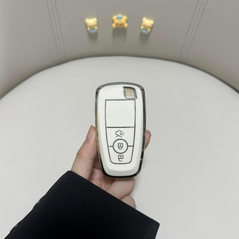 A hand holds a sleek, white lincoln corsair car key cover with a luxury shell design, featuring a lock and unlock button, set...