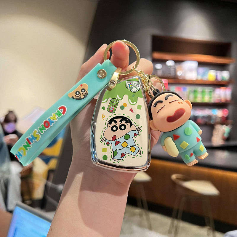 A hand holds a vibrant keychain featuring a cartoon character-themed buick envision car key cover and matching key shell case...
