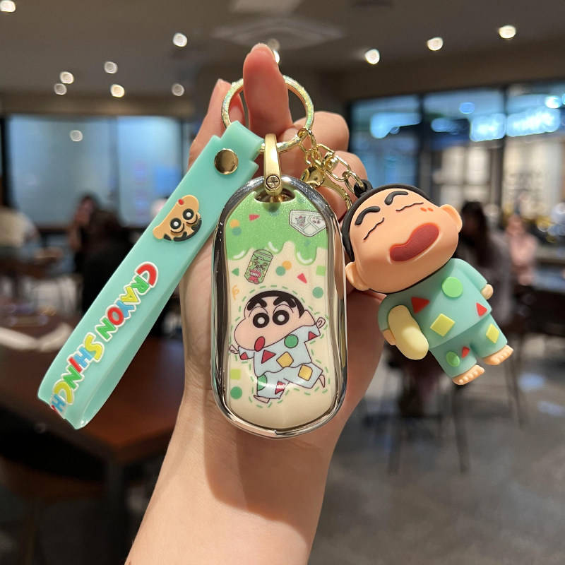 A hand holds a buick envision car key cover featuring a cute cartoon design with a character in colorful pajamas, accompanied...