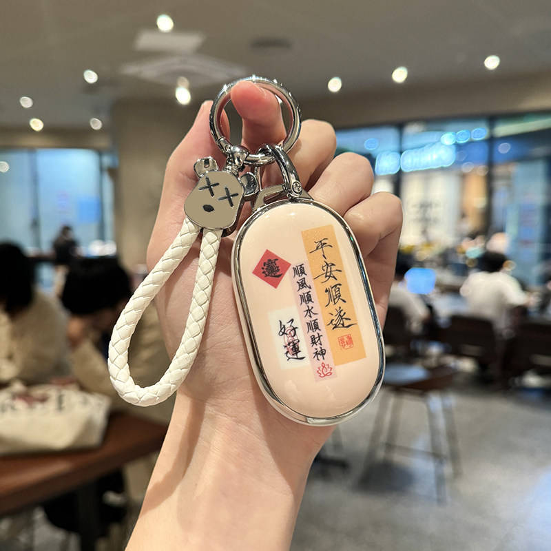 A hand holds a geely geometry starry wish key cover, featuring a cute design with chinese blessings like and , attache...