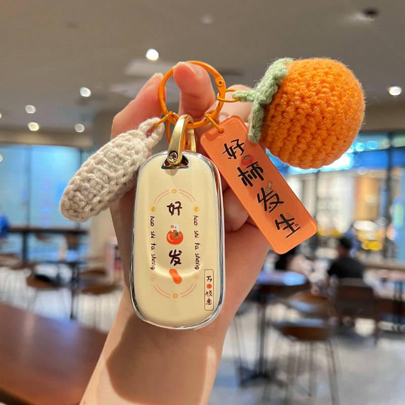 A hand holds a stylish buick regal car key cover with a premium shell case, featuring a good fortune design and playful orang...