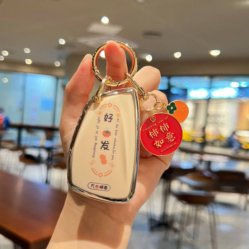 A hand holds a stylish buick enclave plus car key cover with a leather shell case, featuring everything will be all right and...