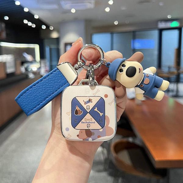 A hand holds a zeekr 001 smart key shell case featuring a cute dachshund design with a blue strap and matching keychain, set ...