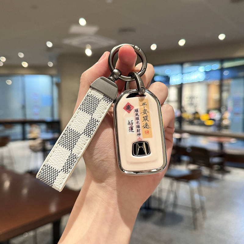 A hand holds a stylish honda cr-v key cover with a checkered strap and chinese characters, designed for models like accord, c...