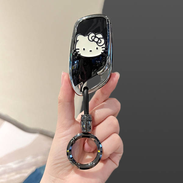 A hand holds a sleek black key cover featuring a white hello kitty design, compatible with roewe rx5 plus, i5, i6, d7, rx5 ma...