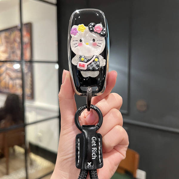 A hand holds a stylish nissan altima 2025 14th gen key cover featuring a cute hello kitty design with floral accents and a ge...