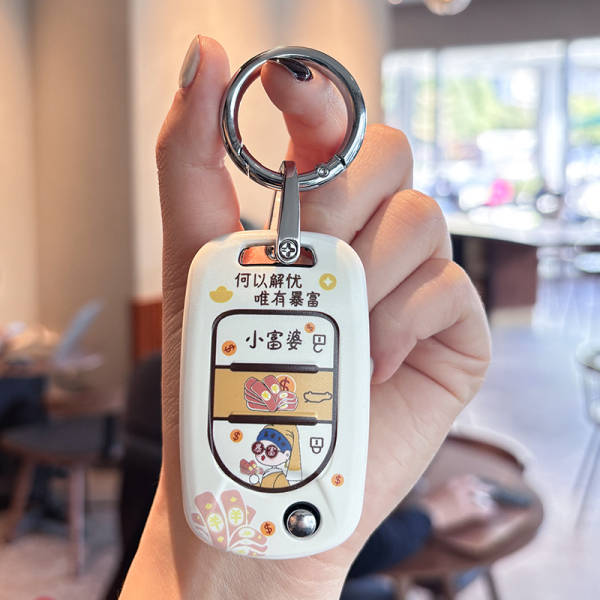 A hand holds a white wuling hongguang mini ev key cover featuring a cartoon little rich lady design with playful text and vib...