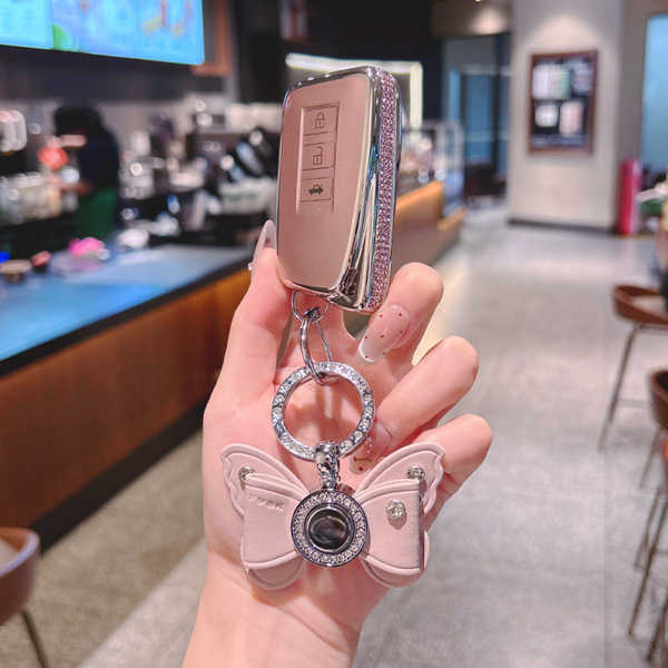 Elegant lexus nx260 key cover for women, featuring a luxurious leather design with a sparkling butterfly charm and a sleek, p...