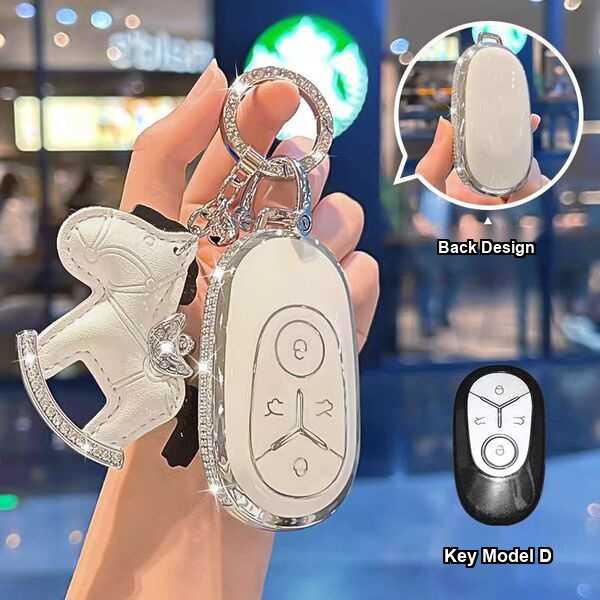 Elegant geely xingyuan key cover 2026 featuring a luxurious white leather design with a decorative horse charm, showcasing bo...