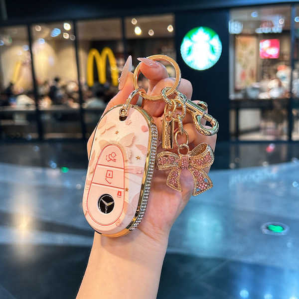 Elegant mercedes c260l key cover with floral design and gold accents, featuring a decorative bow and secure keychain, perfect...