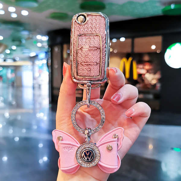 Elegant pink volkswagen key cover for sagitar, bora & magotan, featuring a butterfly charm and sparkling vw logo, perfect for...