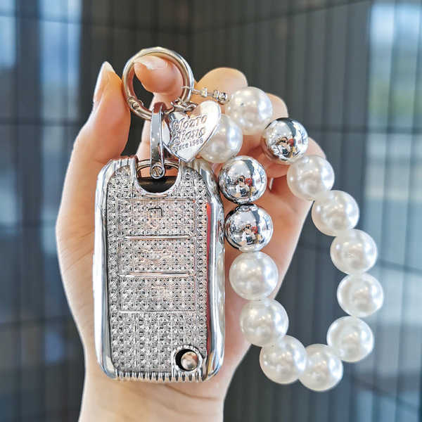 Elegant mg5 key cover adorned with sparkling crystals and a pearl bracelet, featuring a scorpio zodiac charm for a luxurious ...