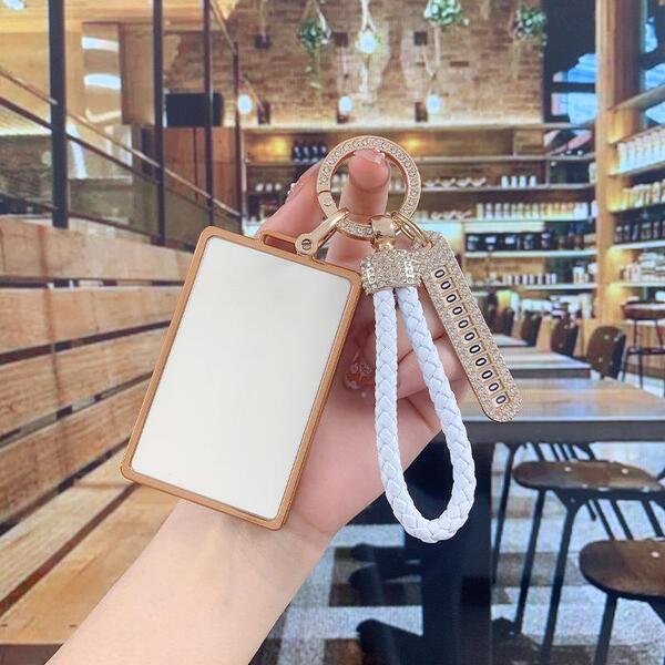 A hand holds a stylish tesla model y key cover featuring a white braided rope and a rectangular card holder, perfect for wome...