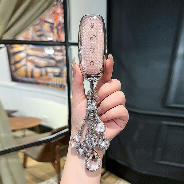 A hand holds a tengshi d9/n7/n8 key cover with an elegant, glittery pink design and crystal embellishments, showcasing its lu...