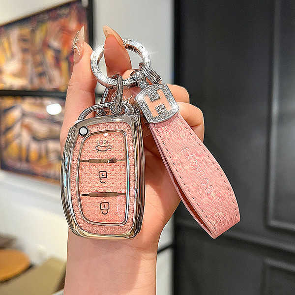 A hand holds a stylish pink leather key cover for hyundai models like the ix35, ix25, and elantra 7th gen, featuring a sleek ...