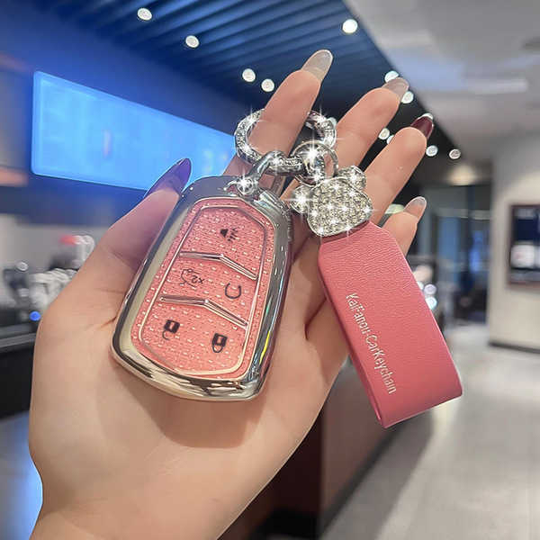 Elegant pink cadillac xt5 key cover with glittery design, featuring a matching pink leather strap and sparkling charm, perfec...