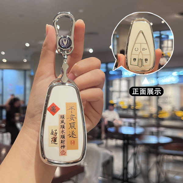 A hand holds a stylish changan cs55 key cover with elegant chinese blessings, featuring a sleek design and a secure clip for ...