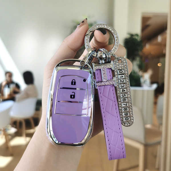 A hand holds a stylish purple toyota key cover for models like camry, corolla, and rav4, featuring a sleek design with a matc...