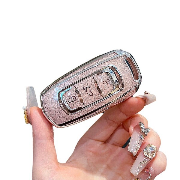 A hand holds a sleek, pink leather key cover designed for geely emgrand gs, boyue x3, and vision models, featuring a shiny me...
