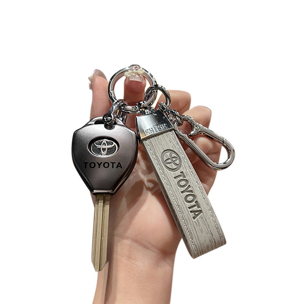 A hand holds a toyota key cover and matching leather keychain, featuring the toyota logo, designed for camry, corolla, rav4, ...