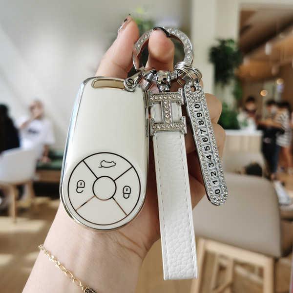 Elegant white key cover for ora good cat, featuring a sleek design with a cloud and car icon, adorned with a sparkling keycha...