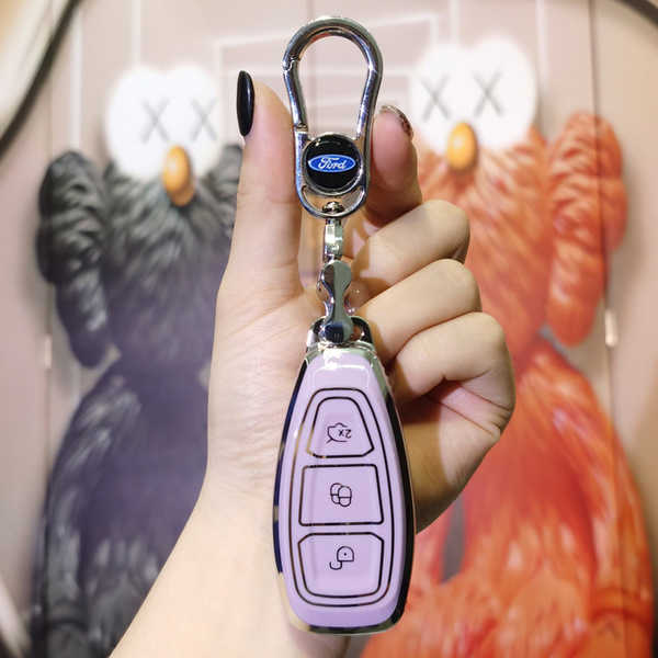 A hand holds a sleek, light purple ford mondeo zhi sheng key cover with a silver carabiner and ford logo, set against a vibra...