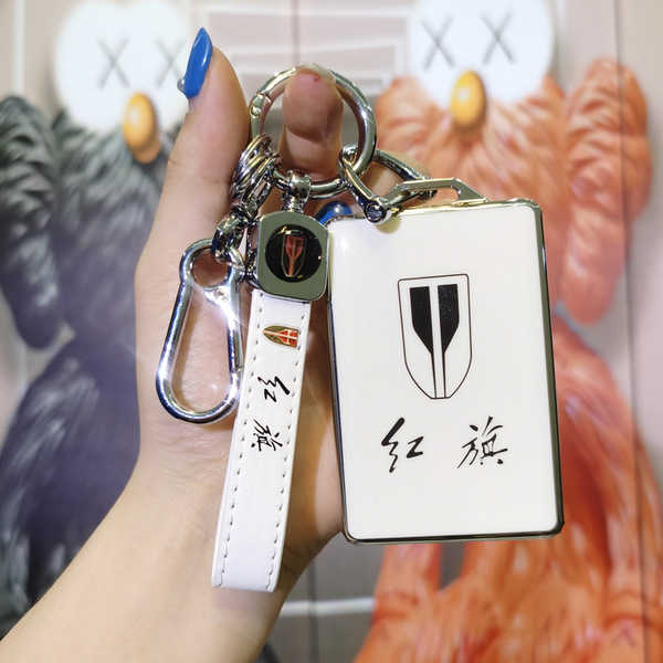 A hand holds a hongqi hs5 card key cover, featuring a sleek white leather design with the iconic hongqi logo and chinese char...