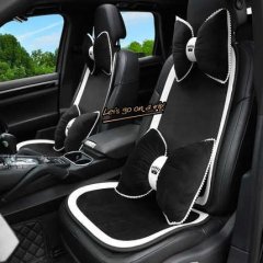 Elegant black and white plush car seat cushion set with bow accents, perfect for a cozy winter drive.