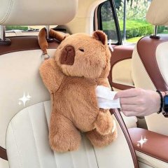 A hand pulls a tissue from the kapibala plush car tissue box, a cute hanging cartoon bear attached to a car seat headrest. th...
