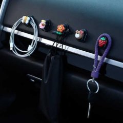 Mini cartoon car hooks neatly organize cables and keys on a car dashboard, featuring playful designs like strawberries and pu...