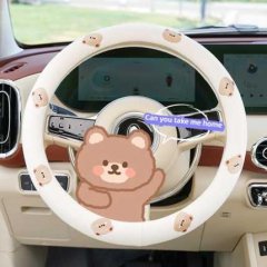 Cotton-linen steering wheel cover featuring a cute cartoon bear design, offering a non-slip grip for a cozy and stylish drive...