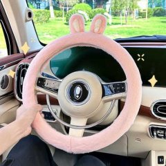 A cozy pink plush steering wheel cover with cute rabbit ears, perfect for keeping hands warm during winter drives.
