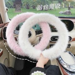 Cozy winter steering wheel cover in soft pink and white plush, offering antifreeze grip for comfortable driving.