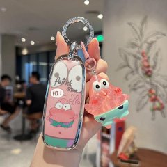A hand holds a gac aion y plus key cover featuring a slim silicone shell with a patrick star design, paired with a matching k...