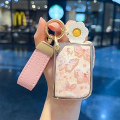 A hand holds a lynk & co 03 car key cover featuring a delicate butterfly design on a soft pink background, complemented by a ...