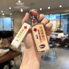 A hand holds a gac trumpchi gs4 key cover featuring and text, paired with a matching keychain, displayed in a cozy ca...