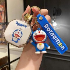 A hand holds a jetour shanhai t2 key cover featuring a doraemon design, including a blue keychain with the character and a ma...